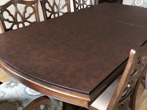 Leather-look dining table protector pad with curved ends and straight sides